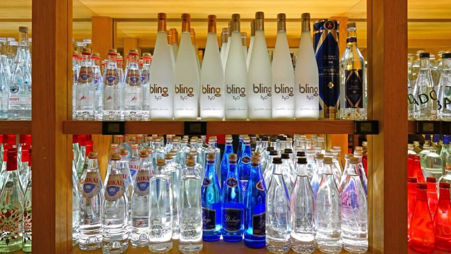 bottles of fancy water lined up on a shelf