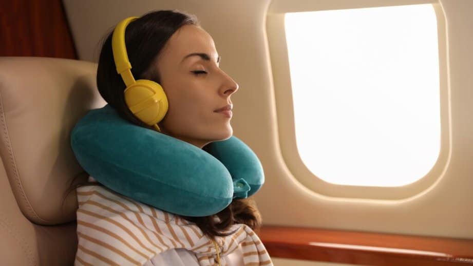 woman on an airplane with a neck pillow