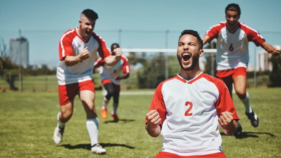 men on a sport field celebrating a win