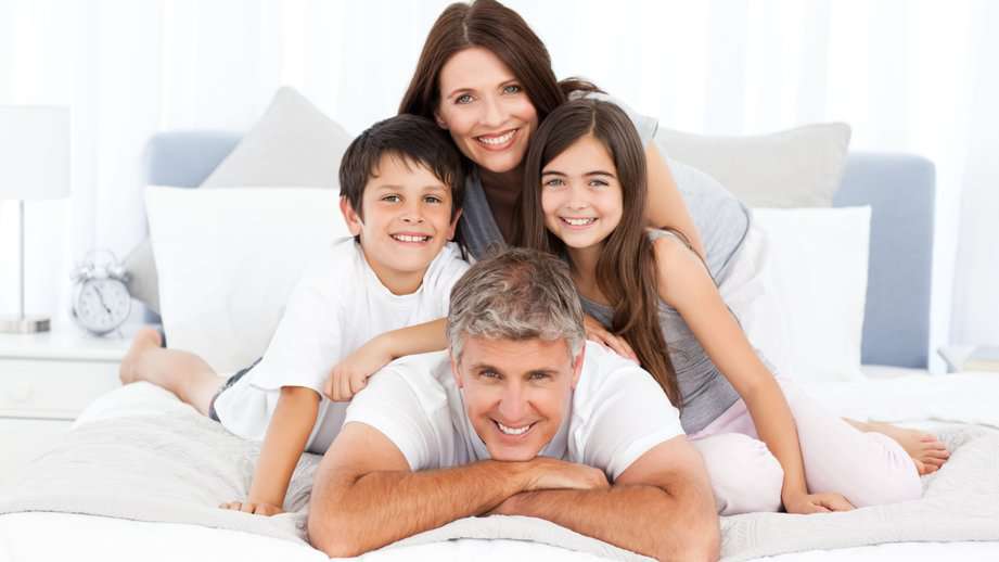 happy family laying on bed in pyramid