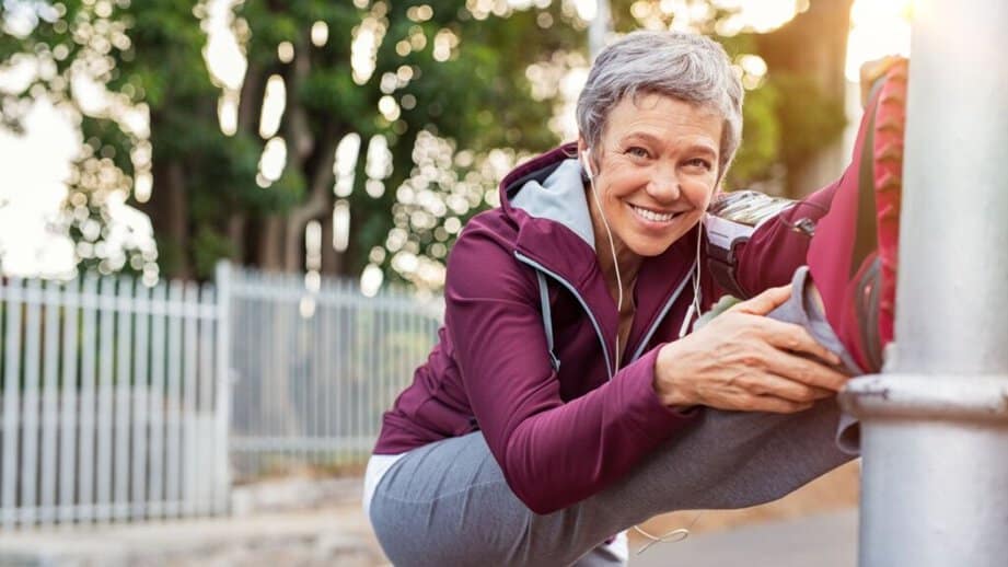 mature senior exercising outside with headphones