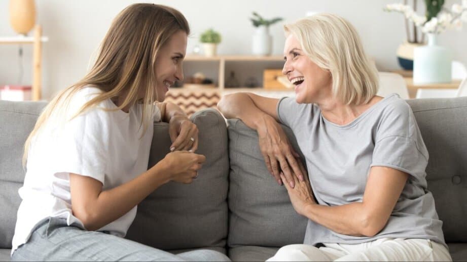 daughter and mother talking on a couch