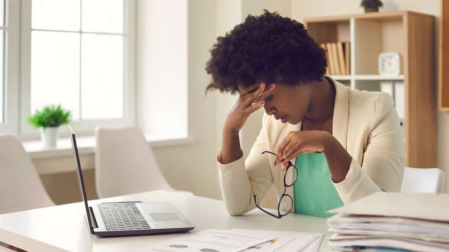 woman overwhelmed at work with head in hands