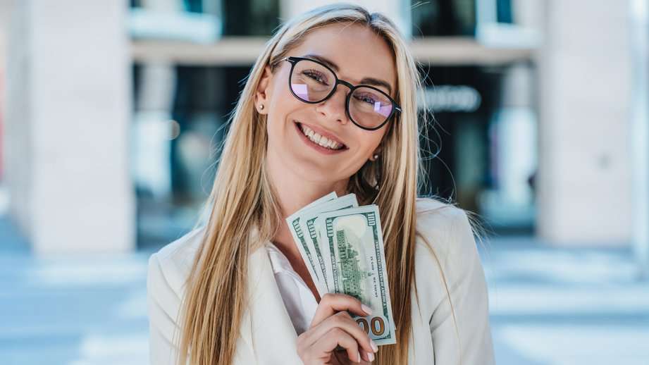 woman with glasses holding money