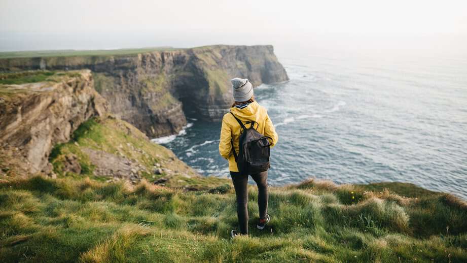 solo traveler on the cliffs of moher in ireland